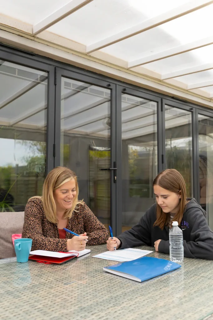 Carer-child-in-care-working-on-assignment-FosteringNorthSomerset